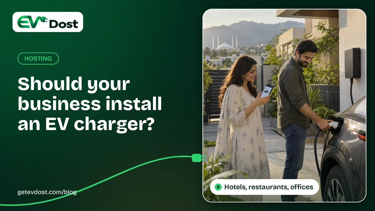 A man plugs in his car at a wall charger while a woman checks her phone, with hills and a mosque behind them at sunset