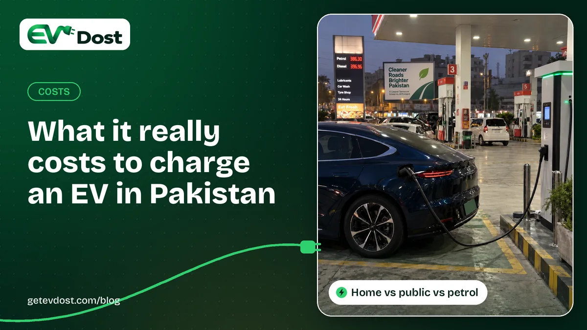 A dark blue electric car charges at a DC fast charger on a fuel station forecourt at night