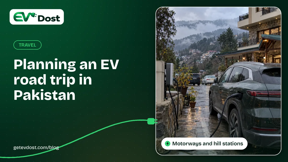 A dark green electric SUV charges outside a stone hotel on a wet, misty hillside street